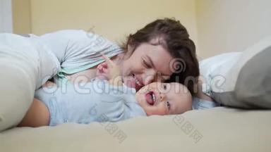 妈妈和宝宝玩捉迷藏的游戏.. 一个女人用毯子盖住宝宝，打开宝宝，两人都笑了